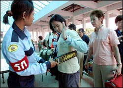 Passengers are screened with metal detectors at Thailand's Hat Yai airport after bombings that killed two. Passengers are screened with metal detectors at Thailand's Hat Yai airport after bombings that killed two.
