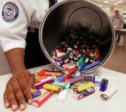 A security screener at Hartsfield-Jackson Atlanta International Airport shows off some of the lighters that have been collected as part of the new ban.