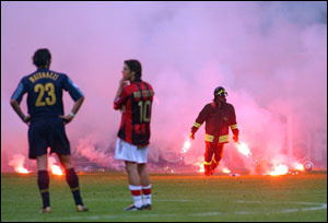 Inter Milan defender Marco Materazzi, left, and AC Milan Portuguese midfielder Rui Costa look on as a firefighter holds flares thrown by fans during their Champions League quarterfinal second leg match at the San Siro stadium in Milan, Italy. Stadium v