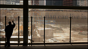Jim Burge, visiting from Bucks County, Pa., looks out onto building materials on the World Trade Center site in New York Tuesday, May 3, 2005. Responding to concerns over the pace of construction for the freedom tower to be built on the World Trade Cen