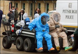 Emergency responders wearing haz-mat suits are driven by the ticket windows during a homeland security disaster training drill at PNC Park in Pittsburgh, Saturday, May 7, 2005. Three thousand volunteers came to the park to test the regions capacity and