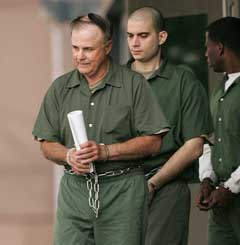 Ronald Allen Grecula, left, is transported from the federal courthouse after making a court appearance Monday, May 23, 2005 in Houston. Grecula has been charged for his involvement in attempting to build and sell an explosive device to an affiliate of al-