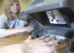 Pam Harvey, an IR marketing employee, inspects one of diversified industrial company Ingersoll-Rand&apos;s biometric security HandReaders. The readers are used at airports, universities and corporations to verify an individual&apos;s identity based on the unique ph