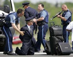 Massachusetts State Police take a captain and co-pilot into precautionary custody as part of a hijacking drill at Logan International Airport on Saturday, June 4, 2005.