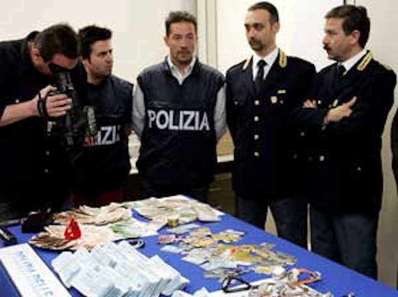 LUCA BRUNO/STF ITALY POSTAL THIEVES Italian Police officers stand by seized money, credit cards and checks during a press conference at the postal Police headquarters in Milan, Italy, Thursday, June 9, 2005. Police pretending to be postal wo