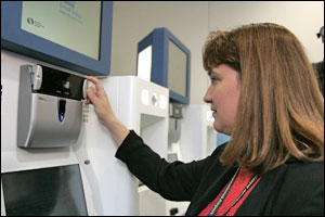 Brigette Rivera Goersch, director of security at the Orlando International Airport, OIA, demonstrates the iris scan at the new 'CLEAR' kiosk at the departure area at the airport in Orlando, Fla., on Tuesday, June 21, 2005.
