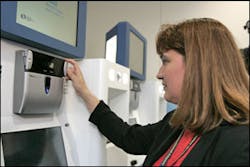 Brigette Rivera Goersch, director of security at the Orlando International Airport, OIA, demonstrates the iris scan at the new &apos;CLEAR&apos; kiosk at the departure area at the airport in Orlando, Fla., on Tuesday, June 21, 2005.