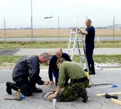 As part of security precautions for a short visit by President Bush to Denmark, even the manhole covers near the airport were secured, shown here being sealed by military personnel, on Tuesday. Security was increased throughout Copenhagen as part of a sto As part of security precautions for a short visit by President Bush to Denmark, even the manhole covers near the airport were secured, shown here being sealed by military personnel, on Tuesday. Security was increased throughout Copenhagen as part of a sto