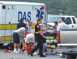 Emergency workers attend to Husain 'Tony' Caddi at the Fort Payne, Ala., Texaco Station at exit 222 on Interstate 59 Friday, Aug. 19, 2005. The gas station owner was run over and killed when he tried to stop a driver from leaving without paying for $52 wo
