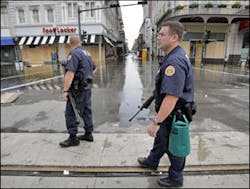 New Orleans police officers watch for looters at the intersection of Canal Street and Bourbon Street in the French Quarter
