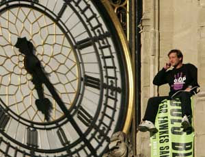 A protester, named by pressure group Fathers 4 Justice as Guy Harrison, unfurls a banner which reads 'Does Blair Care' after he climbed onto the roof of the Houses of Parliament in London on Tuesday, Sept. 27, 2005. Several police officers stood nearby, o