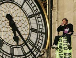 A protester, named by pressure group Fathers 4 Justice as Guy Harrison, unfurls a banner which reads &apos;Does Blair Care&apos; after he climbed onto the roof of the Houses of Parliament in London on Tuesday, Sept. 27, 2005. Several police officers stood nearby, o