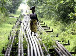 A woman walks along an oil pipeline near Shell's Utorogu flow station in Warri, Nigeria. Militia fighters have attacked an oil platform and kidnapped oil industry workers in the country. A woman walks along an oil pipeline near Shell's Utorogu flow station in Warri, Nigeria. Militia fighters have attacked an oil platform and kidnapped oil industry workers in the country.
