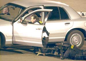 Police officers draw guns and surround the perimeter of the Bank of America in Exeter, Calif., Wednesday, Jan. 25, 2006, during a standoff with an armed suspect holding multiple hostages in Exeter, Calif. The standoff ended peacefully after the last hosta