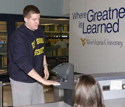 A WVU student uses the handreader technology to enter the student recreation center.