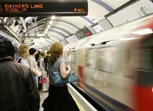 Commuters wait for the arrival of a train at the end of a working day at King Cross Underground Station in London, Friday, July 7, 2006. Friday was the first anniversary of the day four suicide bombers attacked London's transit system killing 52 commuters