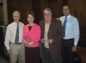 Ron Haner of Alarm Center Inc. (left) and Jon Sargent of ADT (right) join Laura Wohl and Dick Machlan of the Olympia Police Department during the award presentation ceremony.