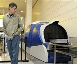 A passenger watches as his carry-on baggage goes through the newly unveiled Analogic Cobra automatic explosive detection system at Baltimore/Washington International Thurgood Marshall Airport (BWI )on Wednesday, Oct. 24, 2007. BWI is one of the first few