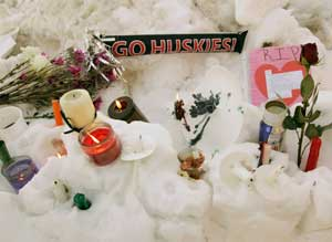 Flowers, candles, and small notes sit in the snow Friday, Feb. 15, 2008, on the campus of Northern Illinois University near Cole Hall, the scene where a lone gunman shot and killed six Thursday on the NIU in DeKalb, Ill.
