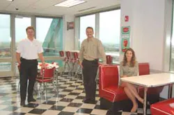 The 1950s diner style break room (a past theme of the company's tradeshow booth) is part of the new offices for Stanley Convergent Security Solutions. Left to Right: Jim Kopplin, Regional Vice President – Central (Aurora, IL); Tony Byerly, Chief Operati The 1950s diner style break room (a past theme of the company's tradeshow booth) is part of the new offices for Stanley Convergent Security Solutions. Left to Right: Jim Kopplin, Regional Vice President – Central (Aurora, IL); Tony Byerly, Chief Operati
