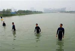 Frogmen wade out of the body of water after a security check near National Stadium, also known as Bird's Nest, background, in Beijing, Thursday, Aug. 7, 2008, a day before the opening ceremony of the Beijing 2008 Olympics. Frogmen wade out of the body of water after a security check near National Stadium, also known as Bird's Nest, background, in Beijing, Thursday, Aug. 7, 2008, a day before the opening ceremony of the Beijing 2008 Olympics.