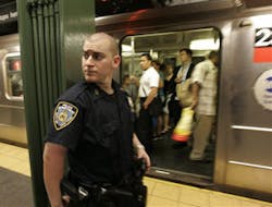 A New York City police officer keeps watch on a platform at the Times Square subway station during an evening rush hour. The FBI and the Homeland Security Department issued a bulletin Tuesday night, Nov. 25, 2008 to state and local law enforcement authori