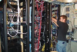 Audio Video Design&rsquo;s Technician Mike Kirby dresses wires at a customer location.
