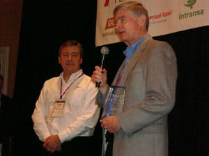 Left, Miguel A. Llerena, regional sales manager for NEC Corp. of America, Santa Clara, Calif., presents the Partner of the Year Award to Bob Sawyer, president and chief executive officer of AMAG Technology Inc.