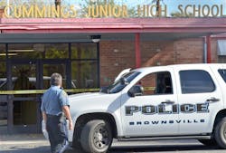 A Brownsville police officer looks at the shattered glass of the front door at Cummings Middle School after police shot and killed an armed eighth-grader who brandished a weapon in the main hallway. A Brownsville police officer looks at the shattered glass of the front door at Cummings Middle School after police shot and killed an armed eighth-grader who brandished a weapon in the main hallway.