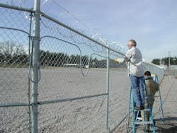 Integrators install detection on a perimeter fence. Integrators install detection on a perimeter fence.