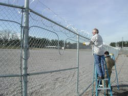 Integrators install detection on a perimeter fence.