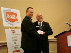 Mike Miller of Moon Security receives a SECURE+ award from Kirk MacDowell, residential business leader, Interlogix and SECURE+Task Force Chair.