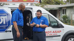 ADT Chief Marketing Officer Tony Wells gets ready for some installation work with Jesus, a service technician.