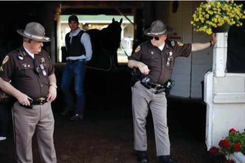 Police officers stand guard outside a barn at Churchill Downs just days before the Kentucky Derby.