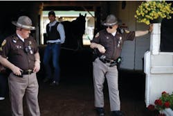 Police officers stand guard outside a barn at Churchill Downs just days before the Kentucky Derby.