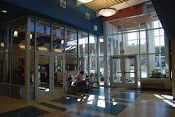 Many schools have an entrance vestibule &mdash; usually a glass enclosed area with locked doors &mdash; that directs visitors to the main office.