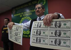 A police officer presents a sample of seized counterfeit U.S. dollars during a news conference in Lima, Peru, on Aug. 11. Police discovered nearly $2 million dollars in phony bills when they raided a restaurant that had a printing machine. A police officer presents a sample of seized counterfeit U.S. dollars during a news conference in Lima, Peru, on Aug. 11. Police discovered nearly $2 million dollars in phony bills when they raided a restaurant that had a printing machine.