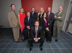 Protection 1 Chairman and CEO Tim Whall, center, surrounded by the company's leadership team. Protection 1 Chairman and CEO Tim Whall, center, surrounded by the company's leadership team.