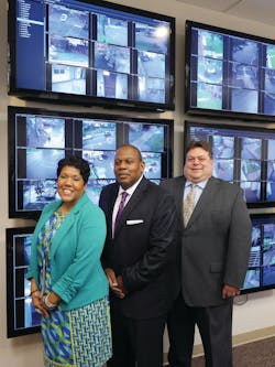The HACP security team gathers in front of the video wall in the command and control center. Joy Pekar-Miller, Director of Public Security (left), Caster Binion, Executive Director (middle), and Edward Mauk, CFO (far right)