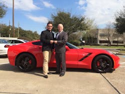 John Sullivan (right), senior vice president of sales at ADI, hands over the keys to a new Chevy Corvette to Ricky Gonzalez, owner of ACI Telephones in Houston TX.