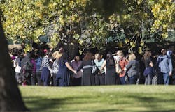 Evacuated workers pray on the San Bernardino Golf Course across the street from a mass shooting at the Inland Regional Center in San Bernardino, Calif., on Wednesday, Dec. 2, 2015.