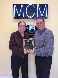Dan Artman of Sielox presents Rich McMillan of MCM Integrated Systems with the company’s 17th consecutive Business Partner of the Year Award. Dan Artman of Sielox presents Rich McMillan of MCM Integrated Systems with the company’s 17th consecutive Business Partner of the Year Award.