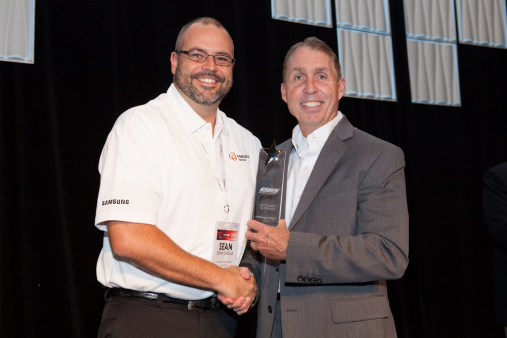 Sean Grimm, national account manager for Hanwha Techwin America, accepts the Star Award from Craig Patterson, director of vendor management at PSA Security Network.