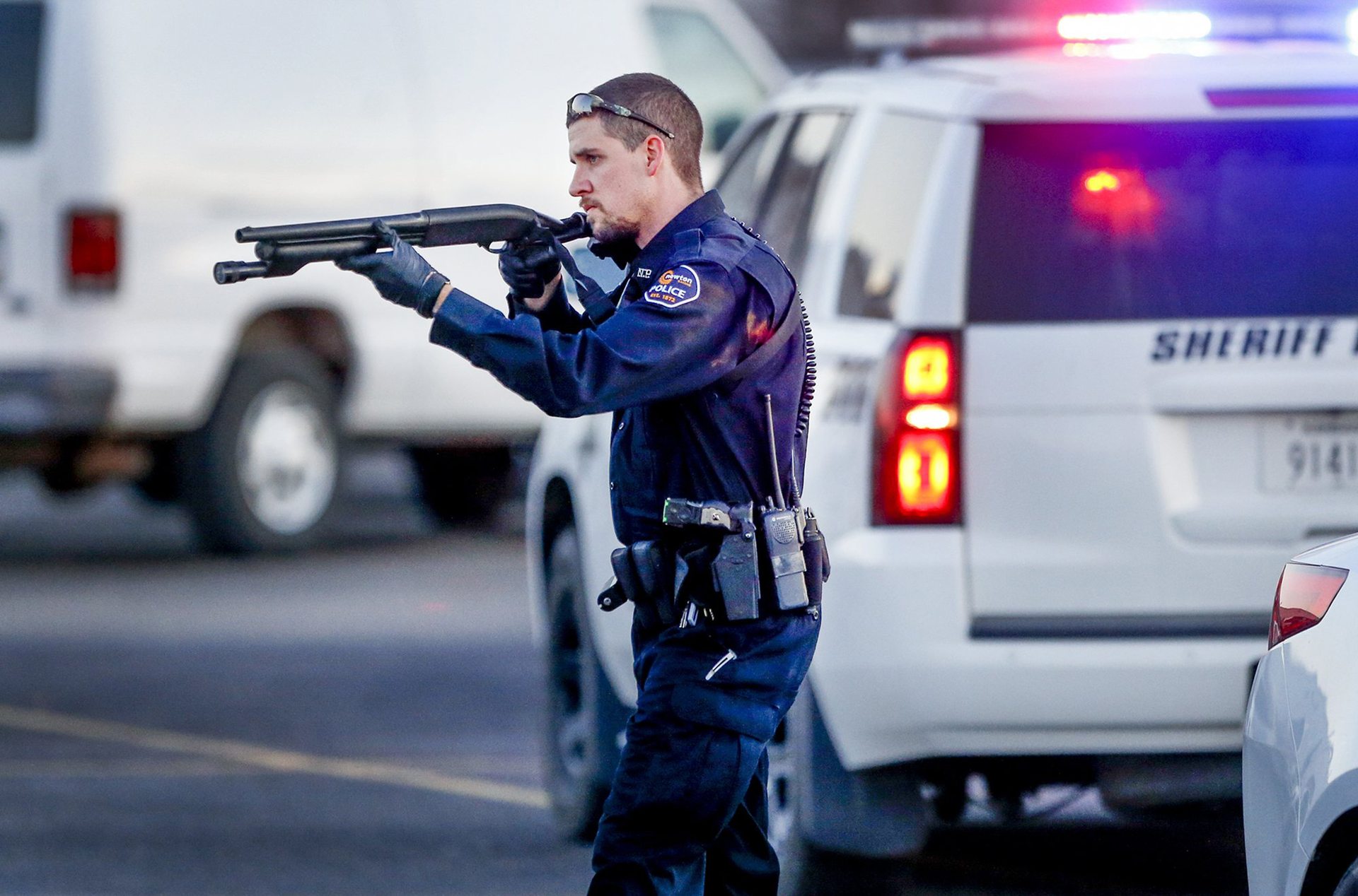 Police go through the parking lot of Excel Industries in Hesston, Kan., where a gunman reportedly killed up to seven people and injured many others on Thursday, Feb. 25, 2016.