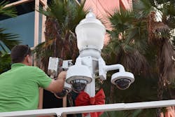 A technician with A+ Technology and Security Solutions installs a millimeter wave radio on a light pole outfitted with surveillance cameras in Fort Myers, Fla.