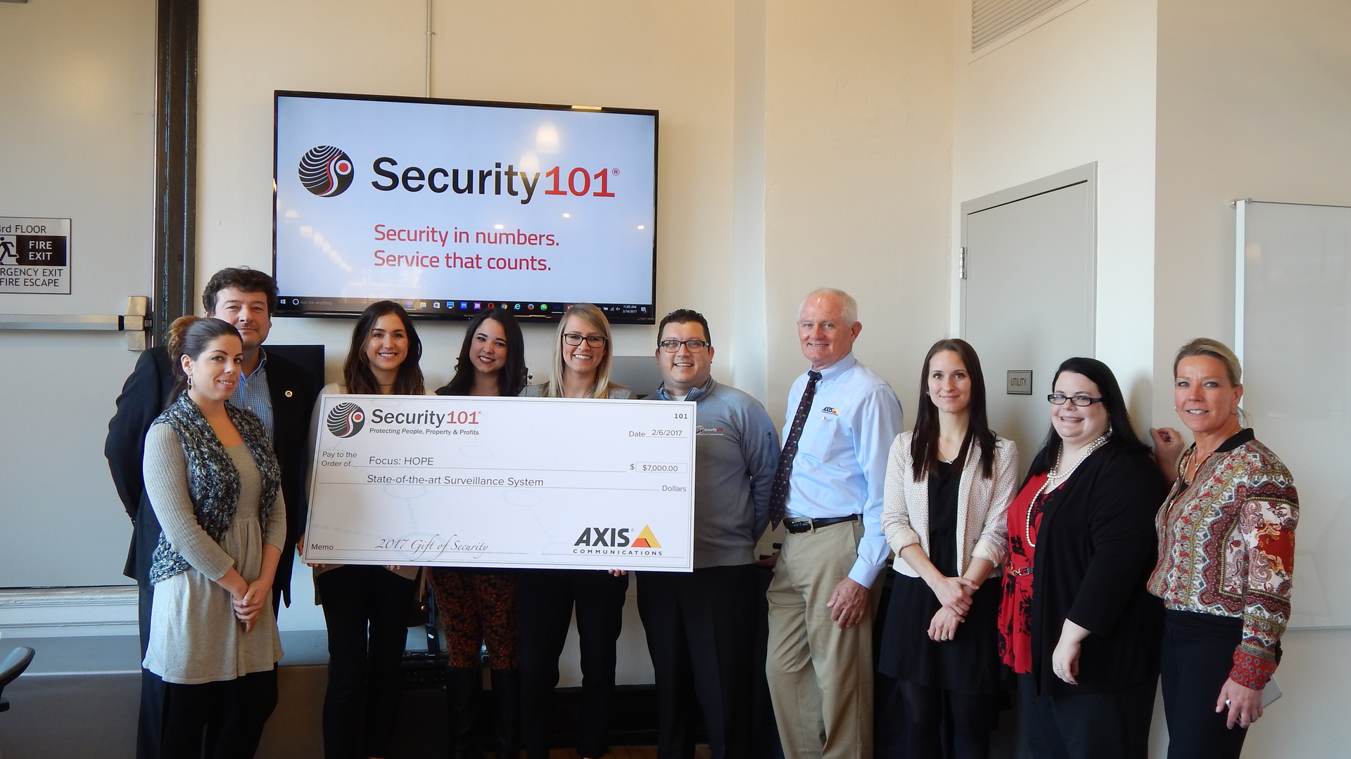 Nathan Zautcke (fifth from right), owner of Security 101's Detroit franchise, and his team present a check for the installation of an Axis video surveillance system and recorder to HOPE, a nonprofit Detroit civil and human rights organization, as part of Security 101&rsquo;s 5th Annual Gift of Security program.