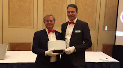Martin Gren, left, and Fredrik Nilsson, right, hold Axis' new IP radar detector at ISC West 2017.