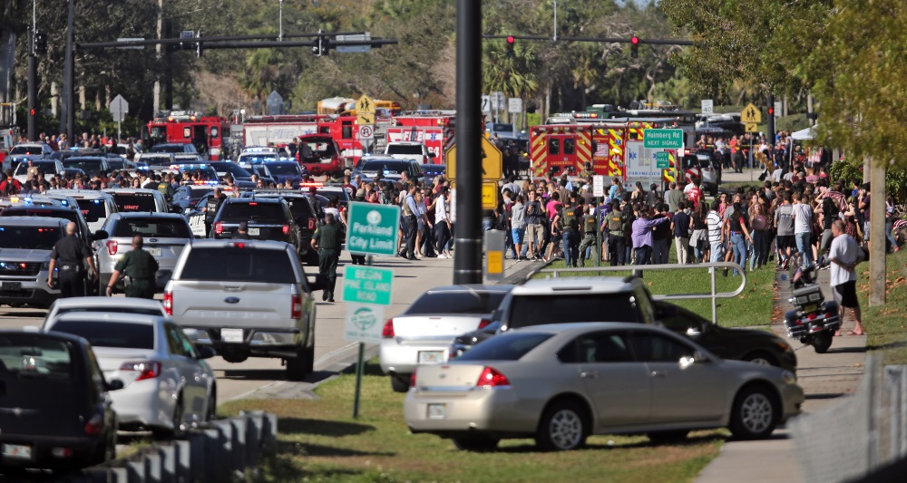 Students are brought across Coral Springs Drive from the campus of Marjory Stoneman Douglas High School in Parkland, Fla., after a shooting on Wednesday, Feb. 14, 2018.