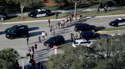 Students are evacuated by police out of Stoneman Douglas High School in Parkland, Fla., after a shooting on Wednesday, Feb. 14, 2018.