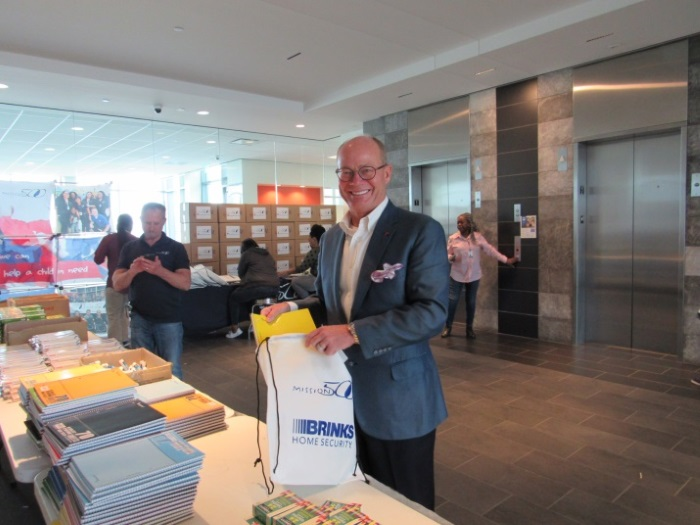 President and CEO of Brinks Home Security, Jeff Gardner, shown assembling a School Refill Pack.